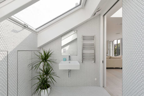 Contemporary bathroom with hexagonal tiles and skylight.