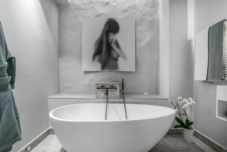 Contemporary bathroom with oval freestanding tub and abstract art.