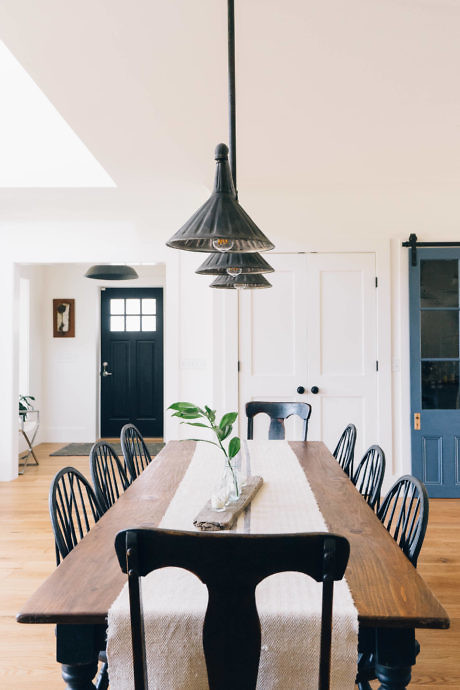 Contemporary dining room with a rustic wooden table and pendant light.