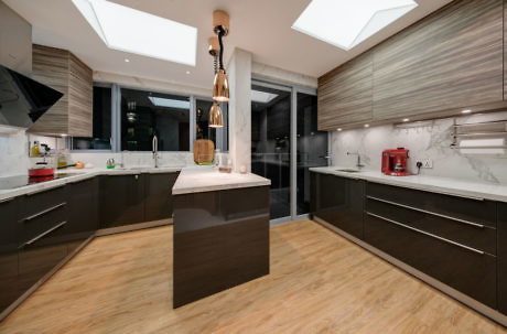 Contemporary kitchen with wood floors, marble counters, and sleek cabinetry.