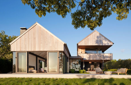 Modern house with asymmetrical pitched roofs and large windows.