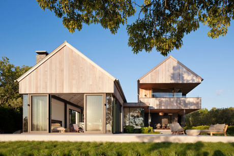 Modern house with asymmetrical pitched roofs and large windows.