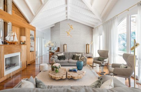 Elegant living room with fireplace, beamed ceiling, and neutral tones.