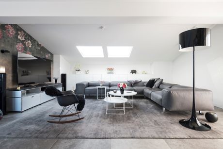 Minimalist living room with sleek furniture and floral wall accent.