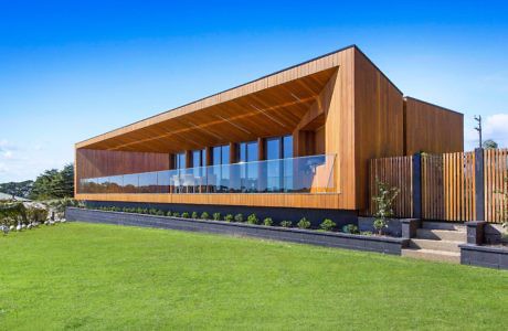 Contemporary wooden building with large windows and angled roof.