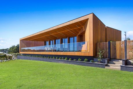 Contemporary wooden building with large windows and angled roof.