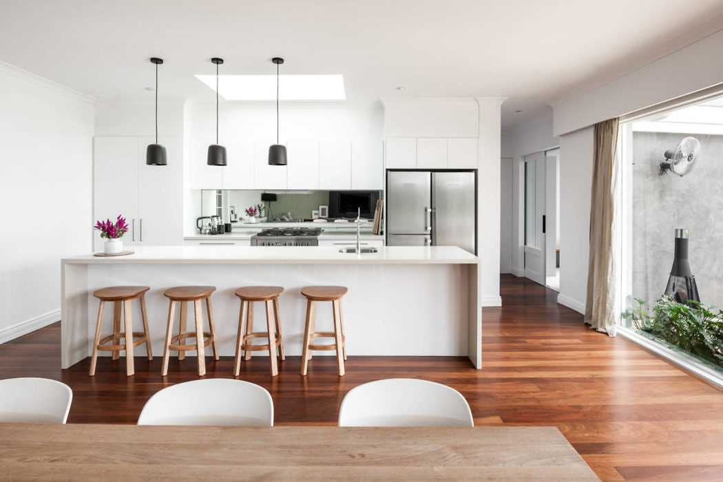 Contemporary kitchen with wooden floors and white cabinetry