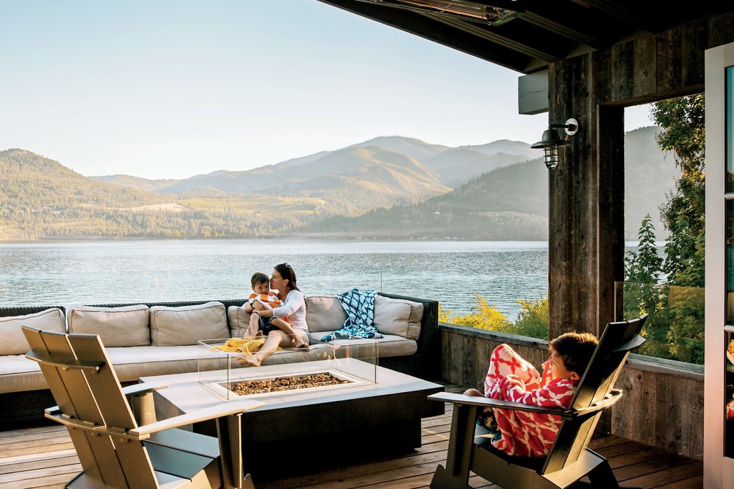 Lakeside outdoor lounge with mountain view and family.
