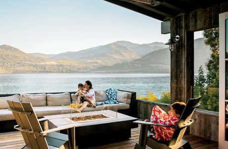 Lakeside outdoor lounge with mountain view and family.