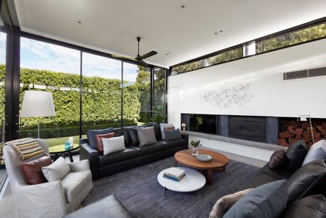 Sleek living room with large windows, fireplace, and minimalist decor.