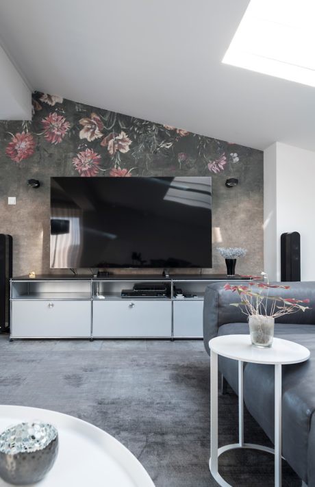 Modern living room with floral wall feature and mounted TV.