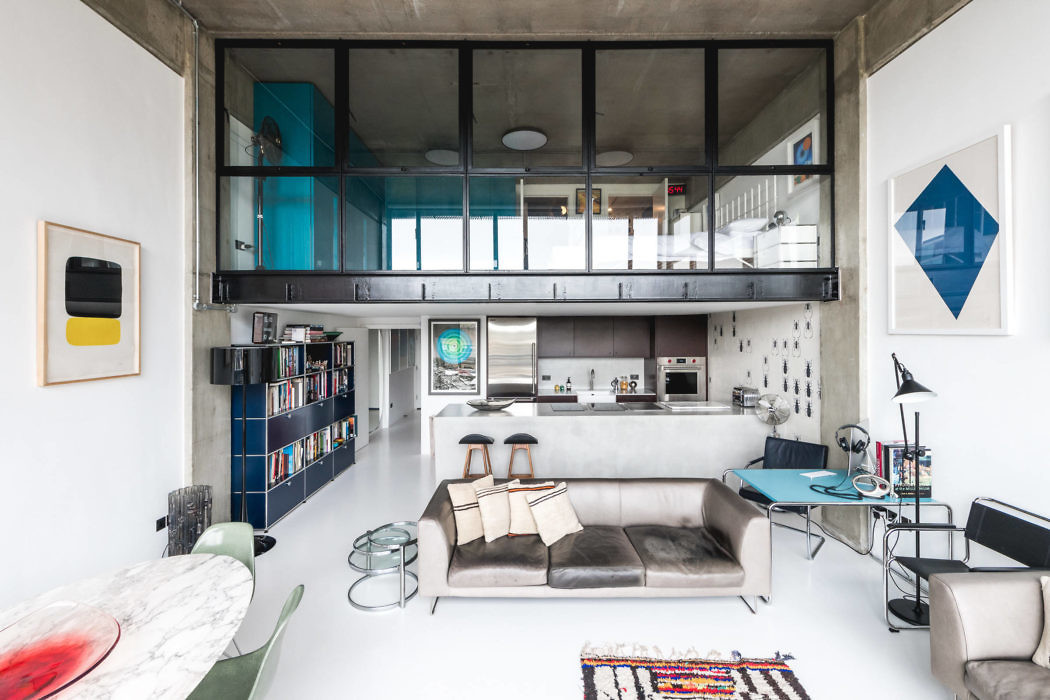 Contemporary loft with mezzanine, industrial finishes, and colorful art.