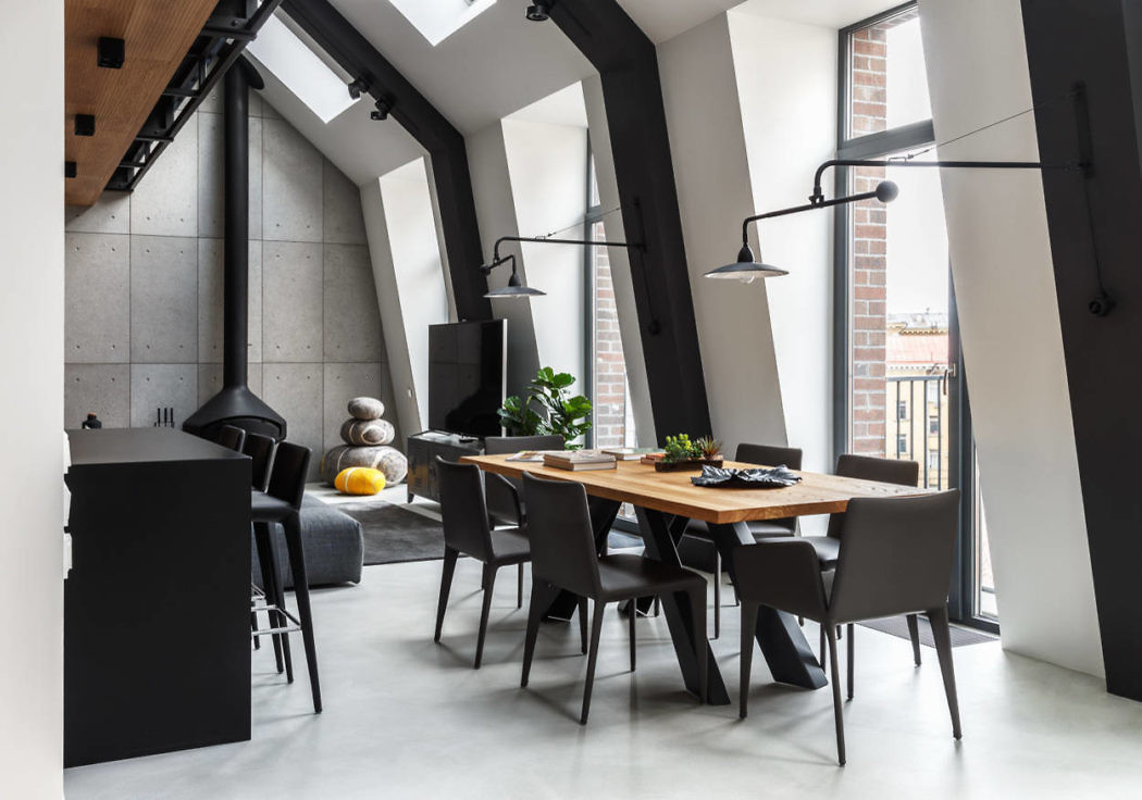 Contemporary dining room with sloped ceilings and monochrome palette.