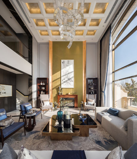 Elegant high-ceiling living room with grand chandelier and golden panel.