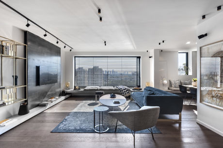 Modern living room with sleek furniture and large window.