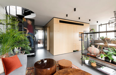 Modern living room with a spiral staircase and wood accents.
