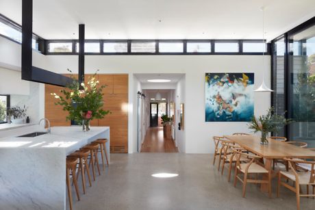 Contemporary kitchen with marble island, wooden accents, and clerestory windows.