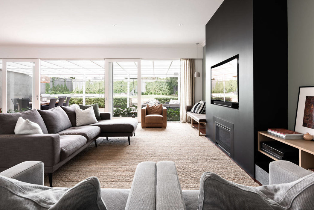 Contemporary living room with neutral tones and large windows.