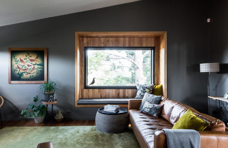 Cozy living room with leather sofa, large window, and wall art.