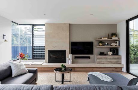 Modern living room with fireplace, TV, and minimalist decor.