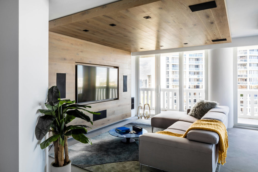 Contemporary living space with wooden ceiling and city view.