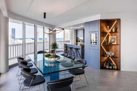 Sleek dining area with glass table, stylish shelving, and ocean view
