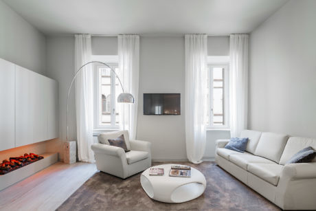 A minimalist living room with elegant archway and sleek furniture.