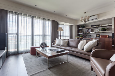 Modern living room with brown sofa, glass table, and large window.