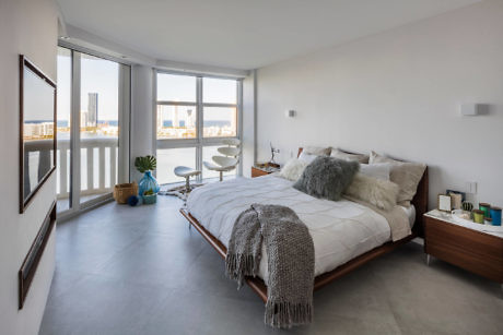 Modern bedroom with large window and city view.
