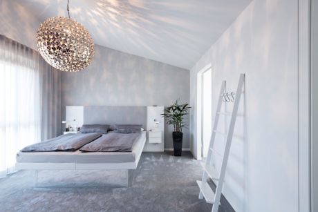 Modern minimalist bedroom with a large, ornate chandelier and floating bed design.