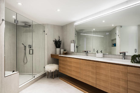 Sleek bathroom with glass shower and wooden vanity.