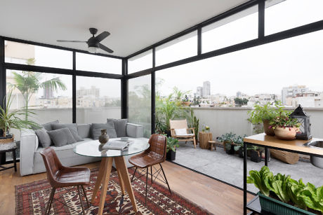 Contemporary sunroom with floor-to-ceiling windows and cityscape view.