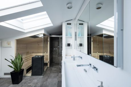 Bright bathroom with skylights and reflective surfaces.