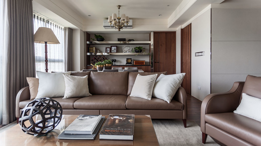 Modern living room with brown leather sofa and elegant decor.