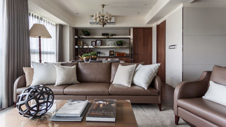 Modern living room with brown leather sofa and elegant decor.