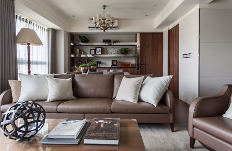 Modern living room with brown leather sofa and elegant decor.