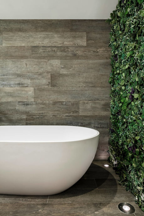 Contemporary bathroom with freestanding tub and green wall.