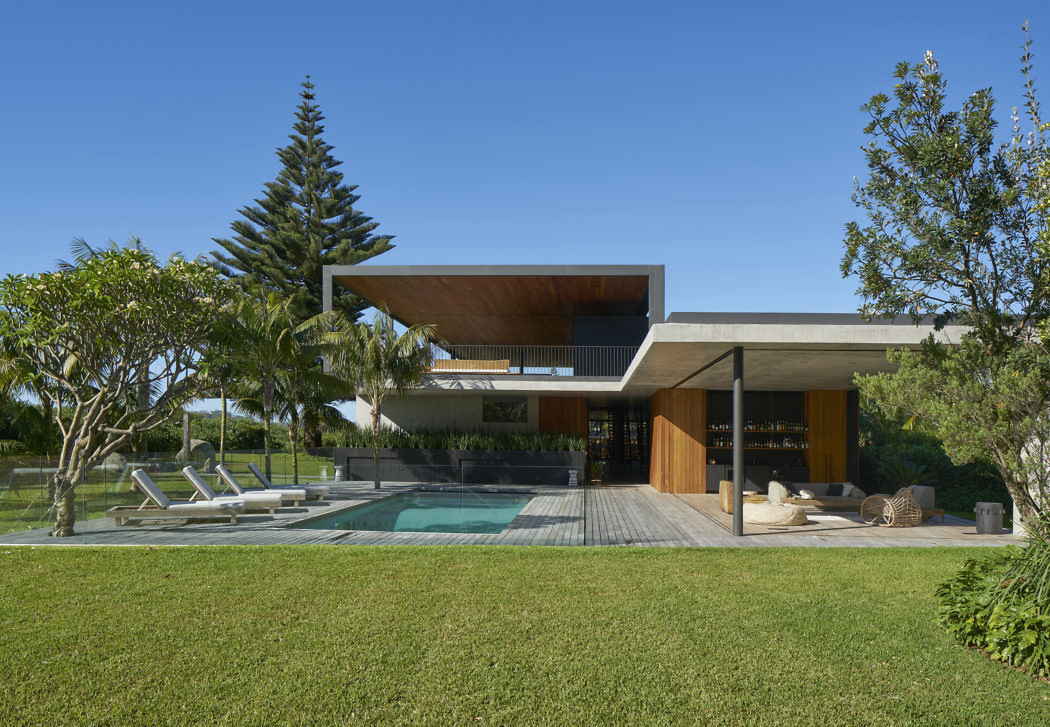 Contemporary house with cantilevered roof overlooking a pool.