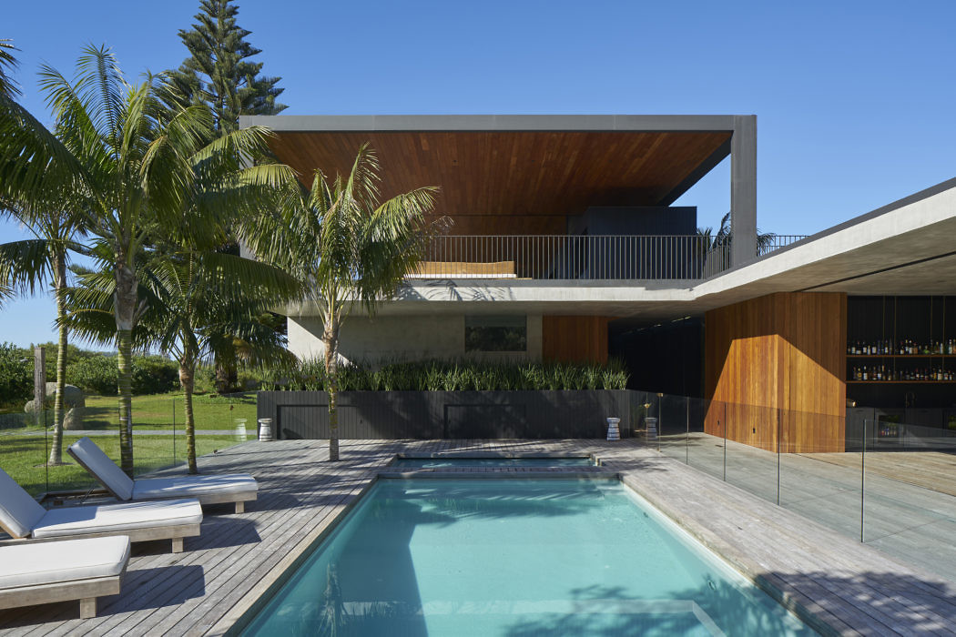 Contemporary house with pool, wooden deck, and cantilevered upper floor