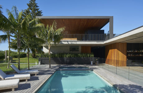 Contemporary house with pool, wooden deck, and cantilevered upper floor