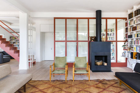 Modern living room with fireplace, bookshelves, and two chairs.