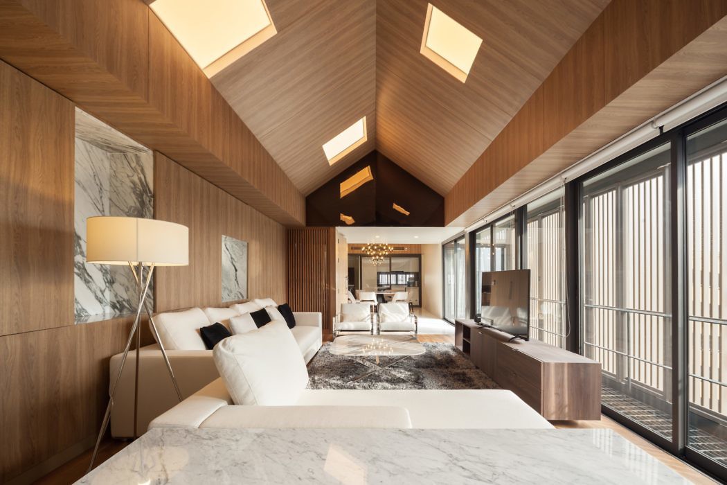 Contemporary wooden interior with marble accents and skylights.