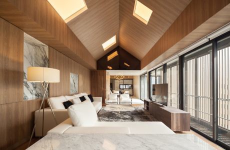 Contemporary wooden interior with marble accents and skylights.