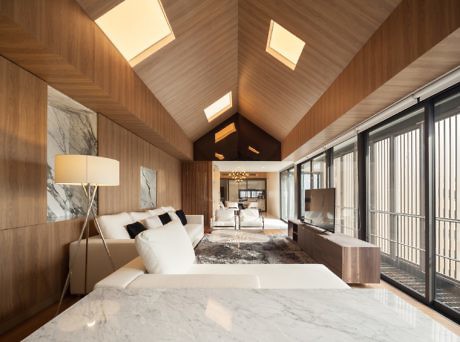 Contemporary wooden interior with marble accents and skylights.