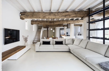 Contemporary living room with exposed wooden beams and minimalist decor.