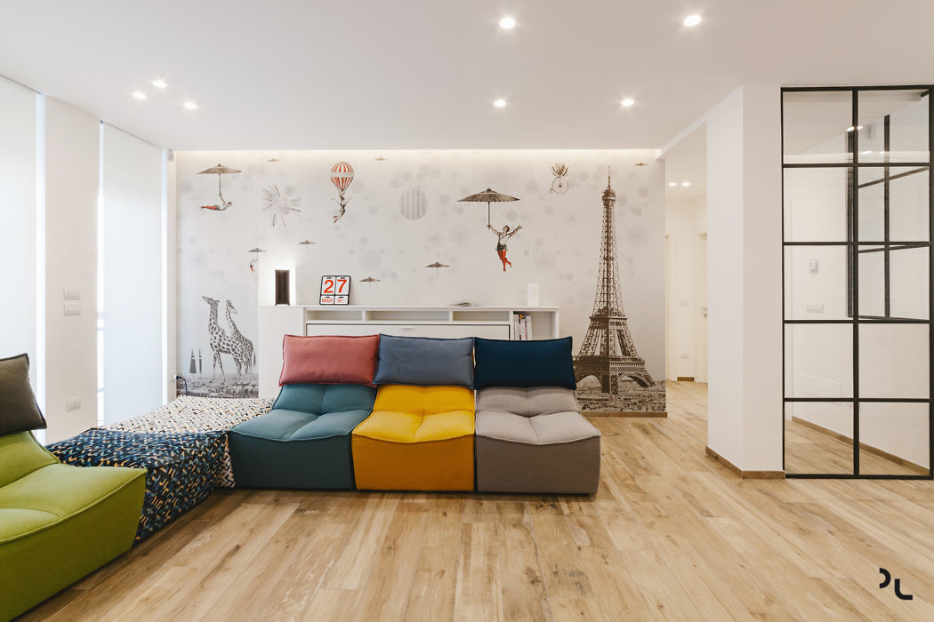 Modern living room with colorful modular sofa and travel-themed wallpaper.