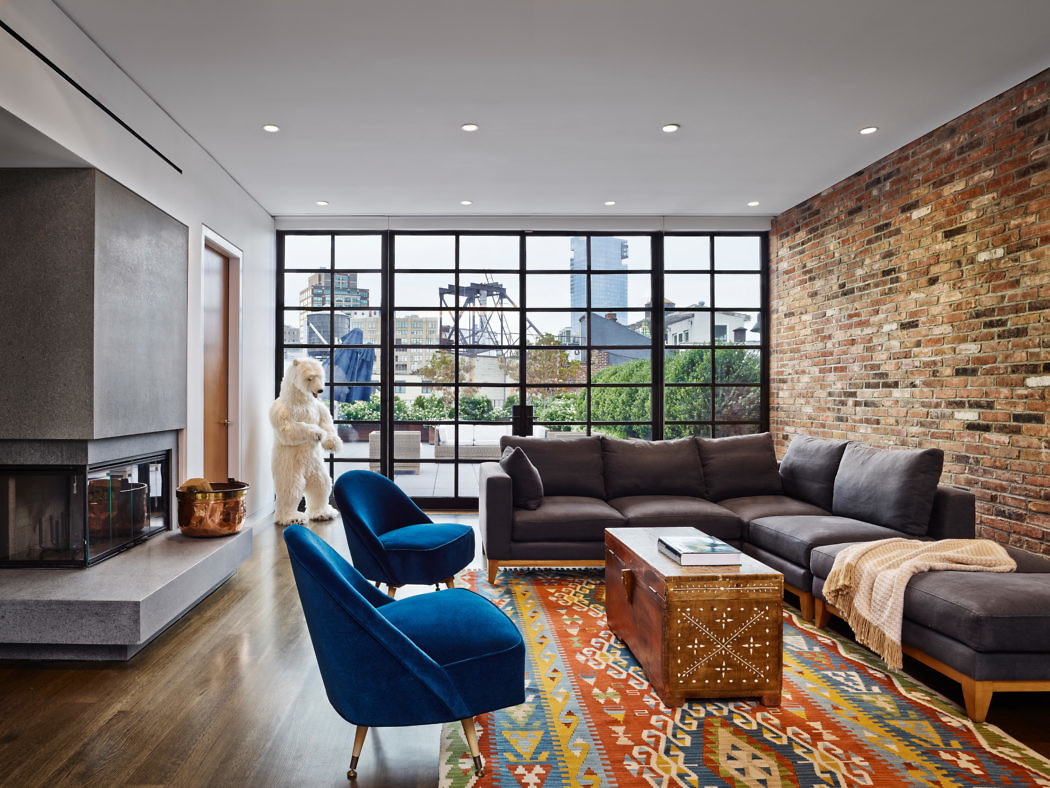 Urban chic living room with exposed brick wall and large windows.