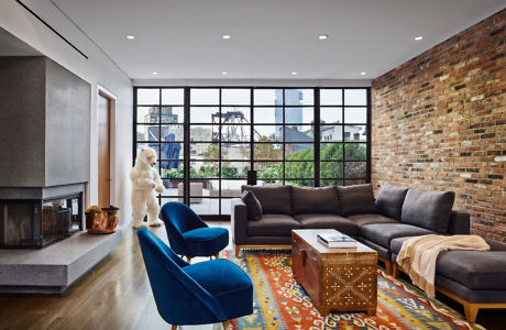 Urban chic living room with exposed brick wall and large windows.