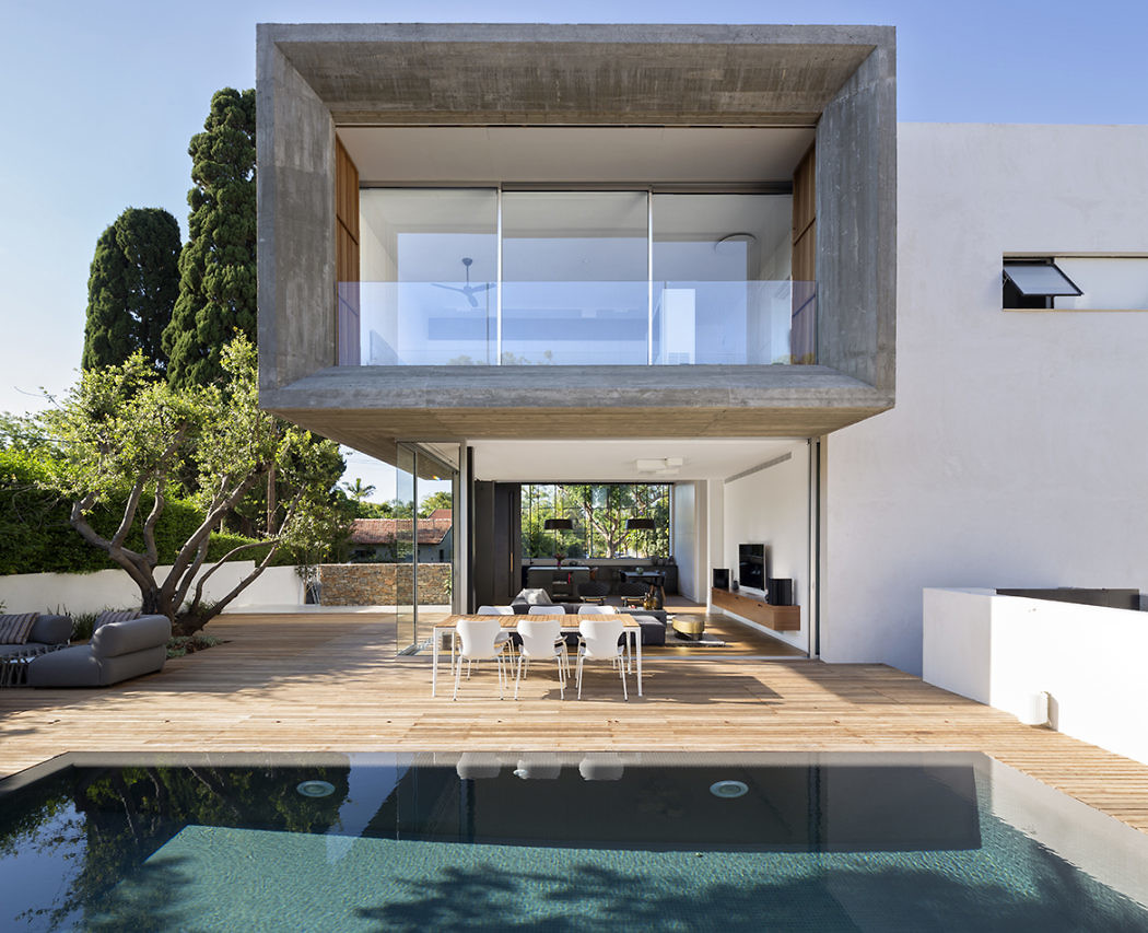 Contemporary house with cantilevered upper floor over poolside dining area.