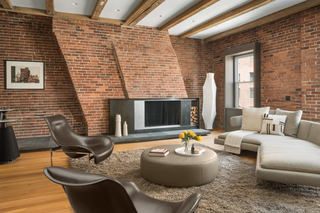 Modern living room with brick walls, fireplace, and contemporary furniture.